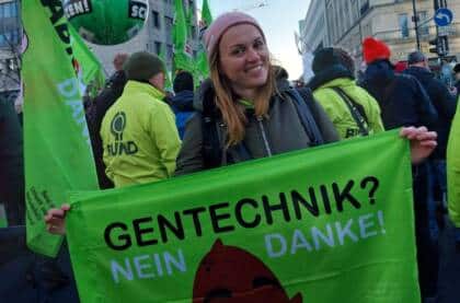 Person auf Demonstration mit Anti-Gentechnik-Banner.